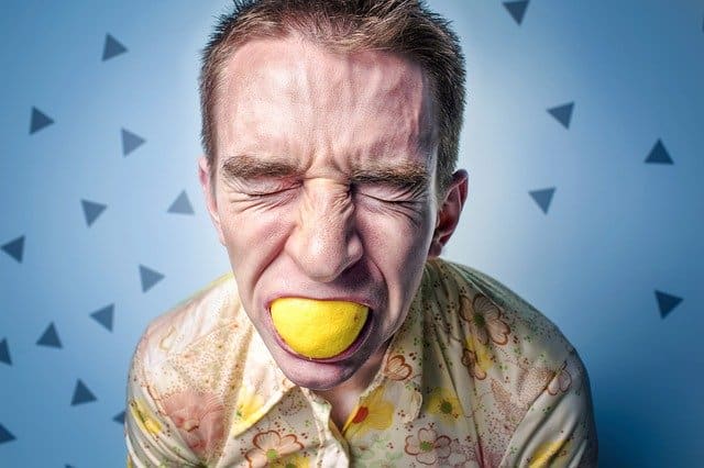 persoon met zuur gezicht en citroen in de mond bij blog over stoppen met contrasteren